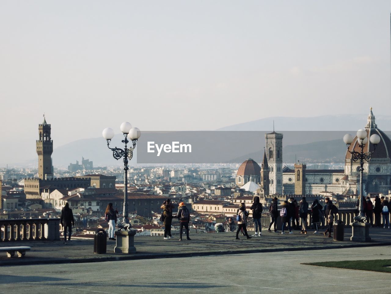 People on footpath with city in background