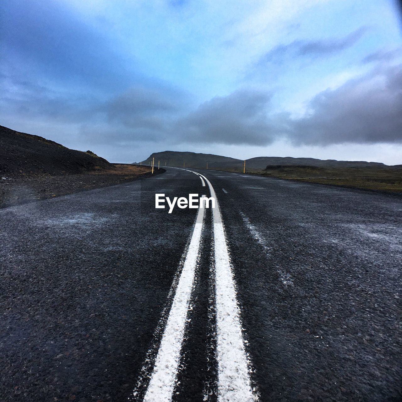 Empty curved road along countryside landscape