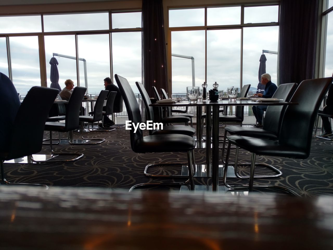 CLOSE-UP OF PEOPLE SITTING ON TABLE IN WINDOW