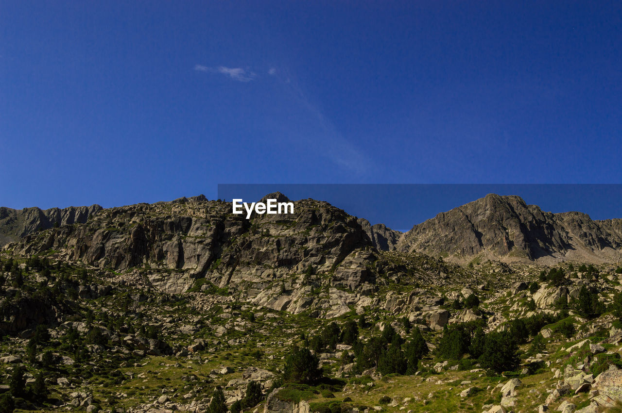 Scenic view of rocky mountains against clear blue sky