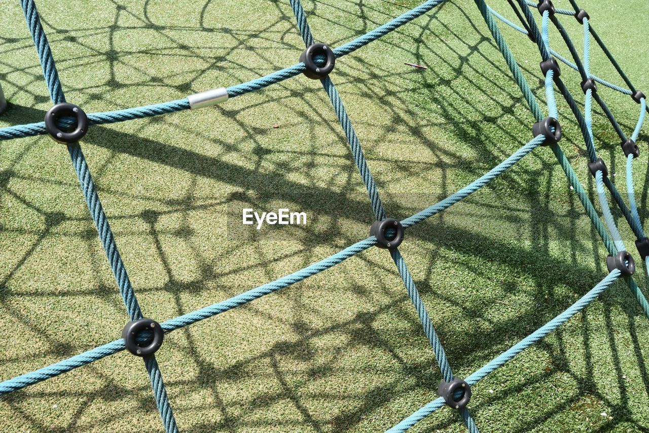 Playground where the sun makes shadow lines on the green floor below