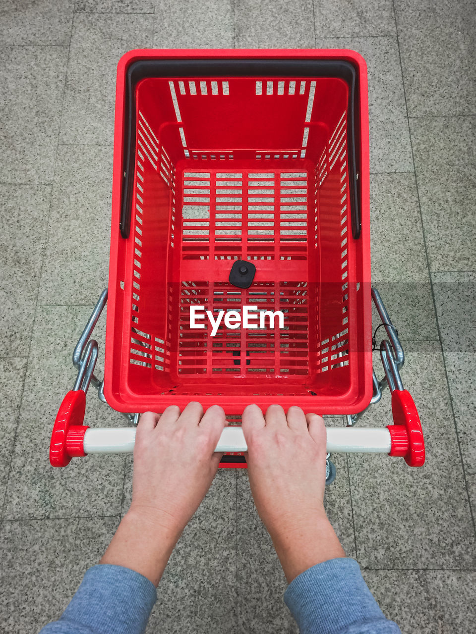 High angle view of woman holding red shopping cart