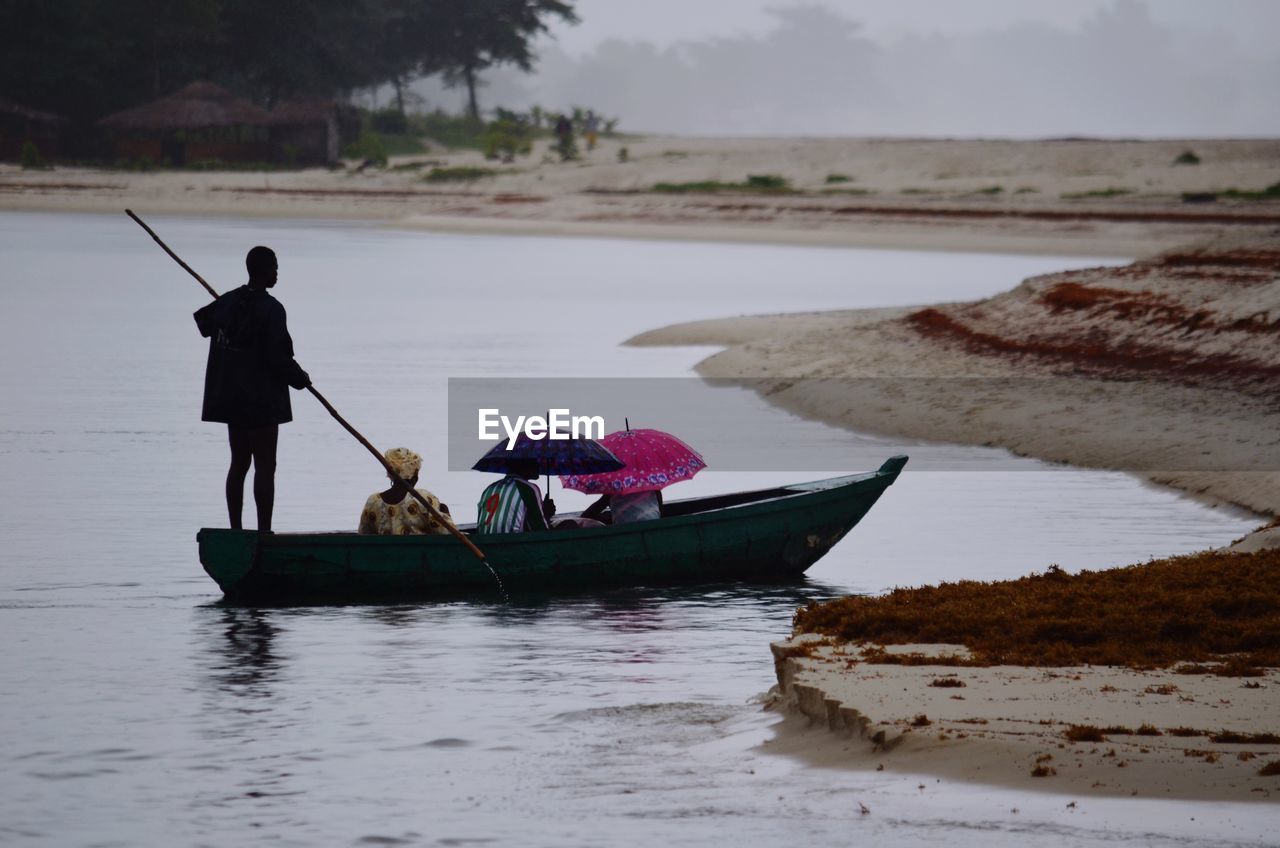 People in boat at lake on rainy day