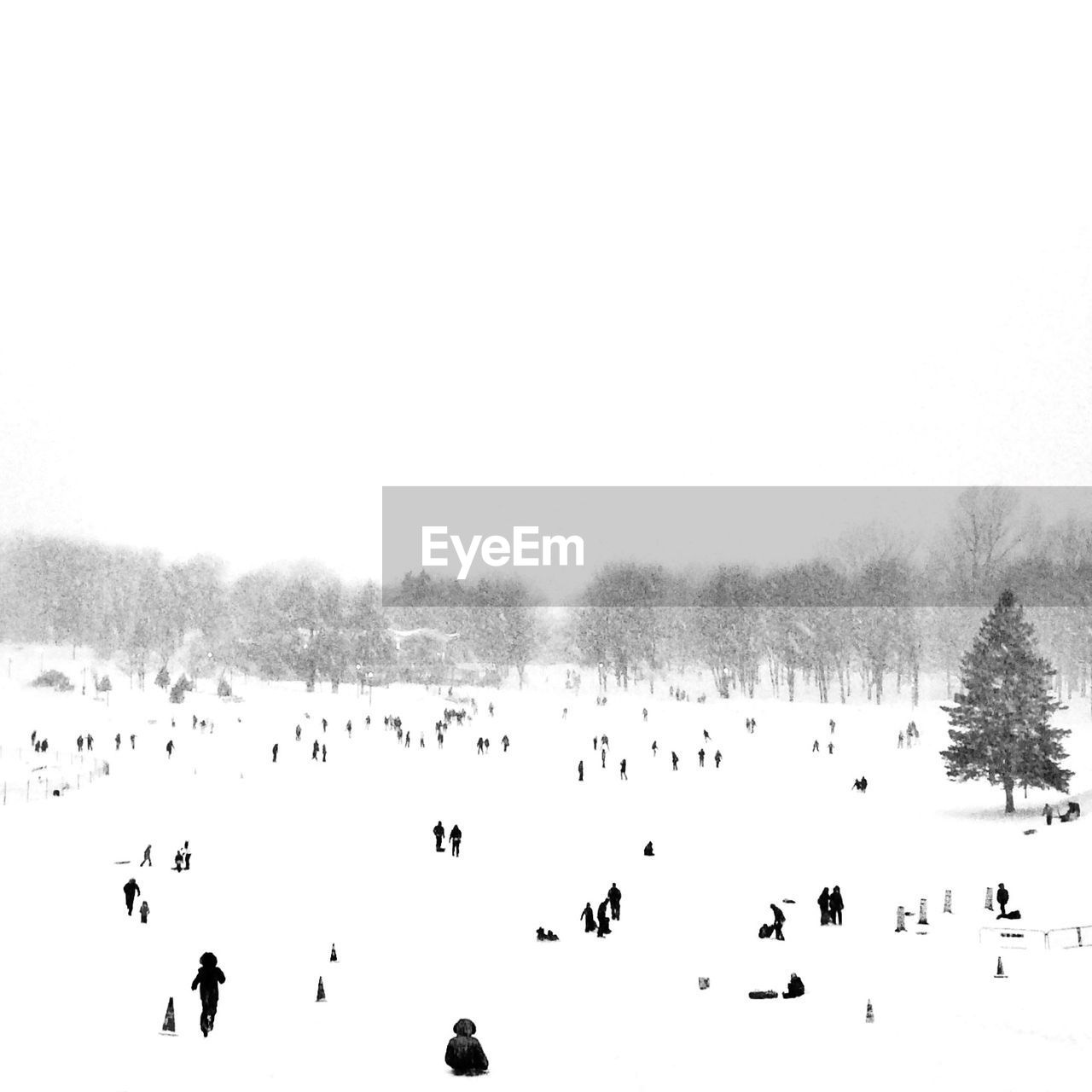People at snow covered field against clear sky