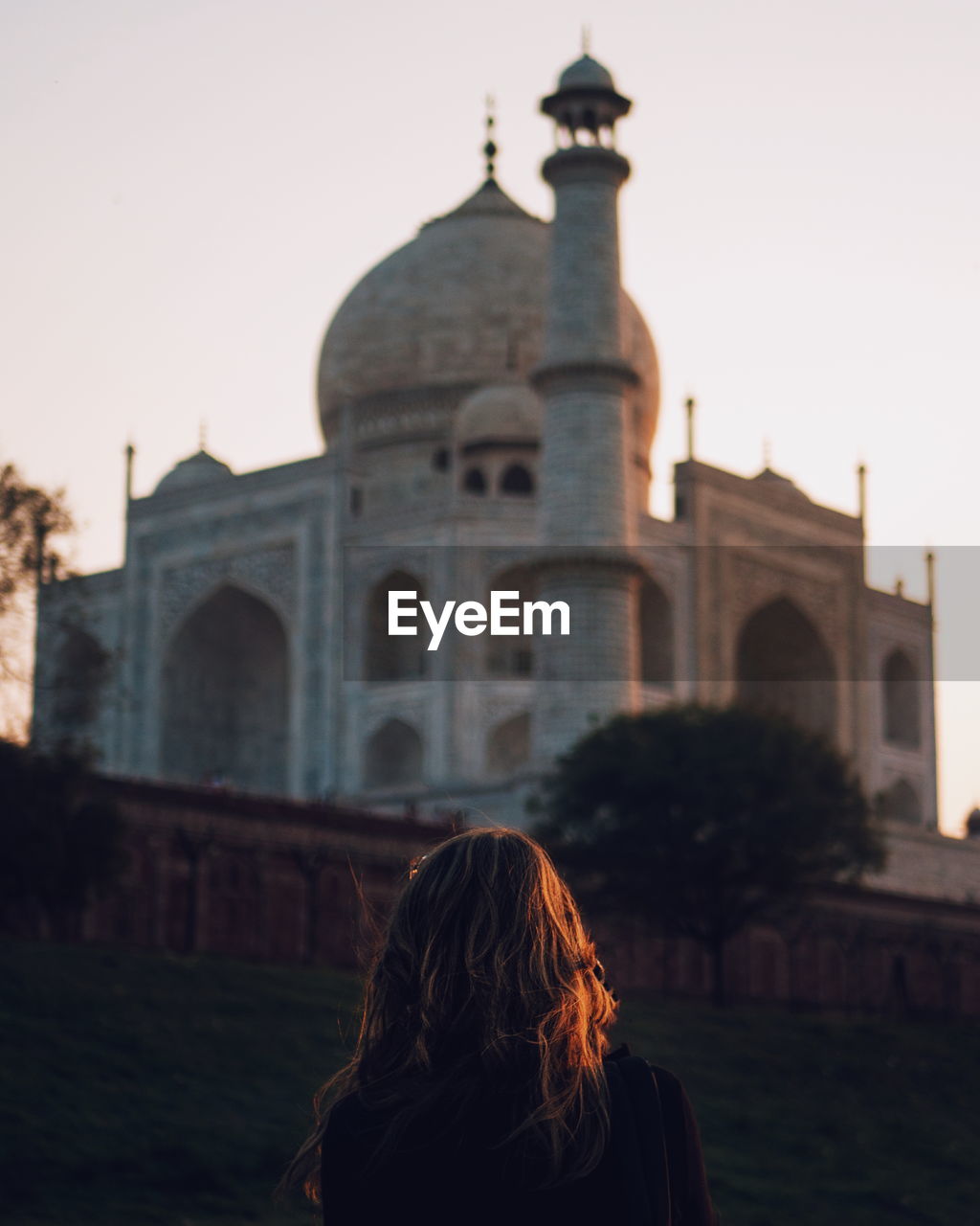 View of woman at historic building against clear sky