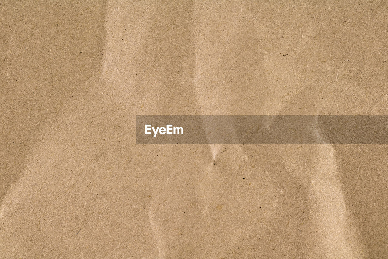 HIGH ANGLE VIEW OF PAPER ON SAND