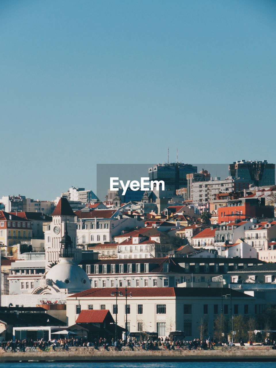 Buildings in city against clear blue sky