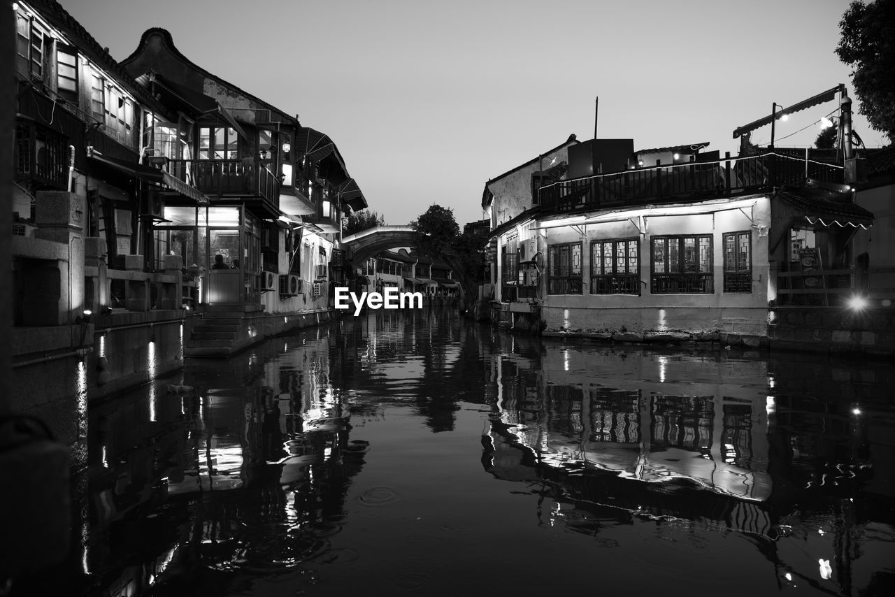 Boats in canal amidst buildings against sky