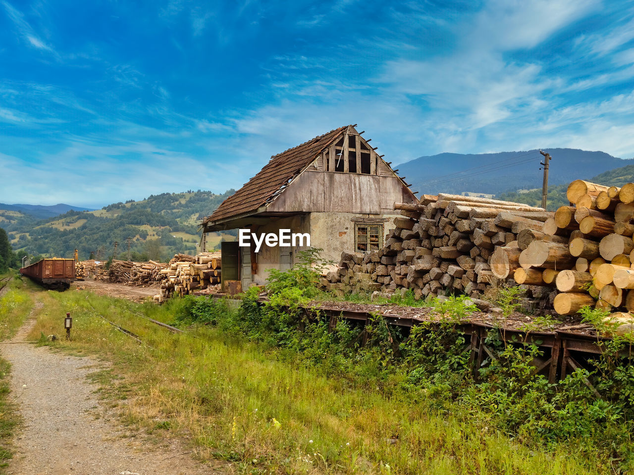 HOUSE ON FIELD BY HOUSES AGAINST SKY