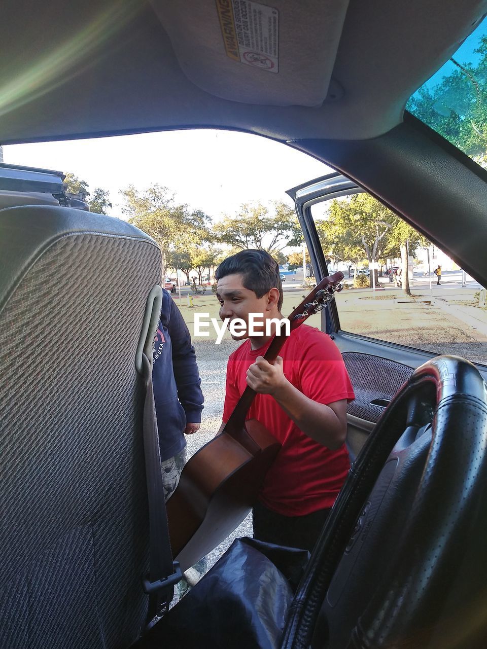 FULL LENGTH OF MAN SITTING IN CAR