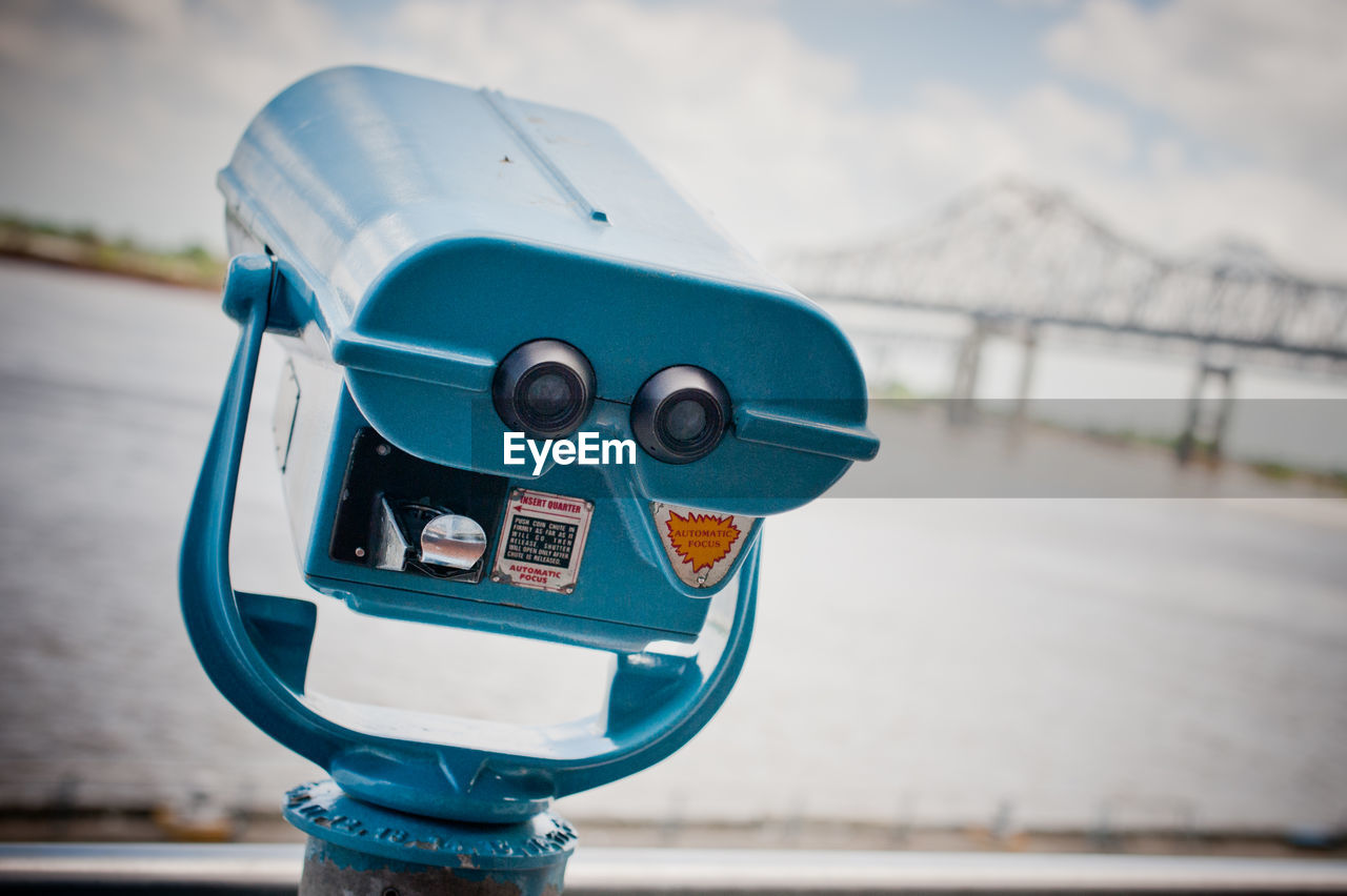 Close-up of coin-operated binoculars against sea