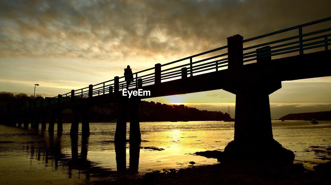 SILHOUETTE BRIDGE OVER RIVER DURING SUNSET