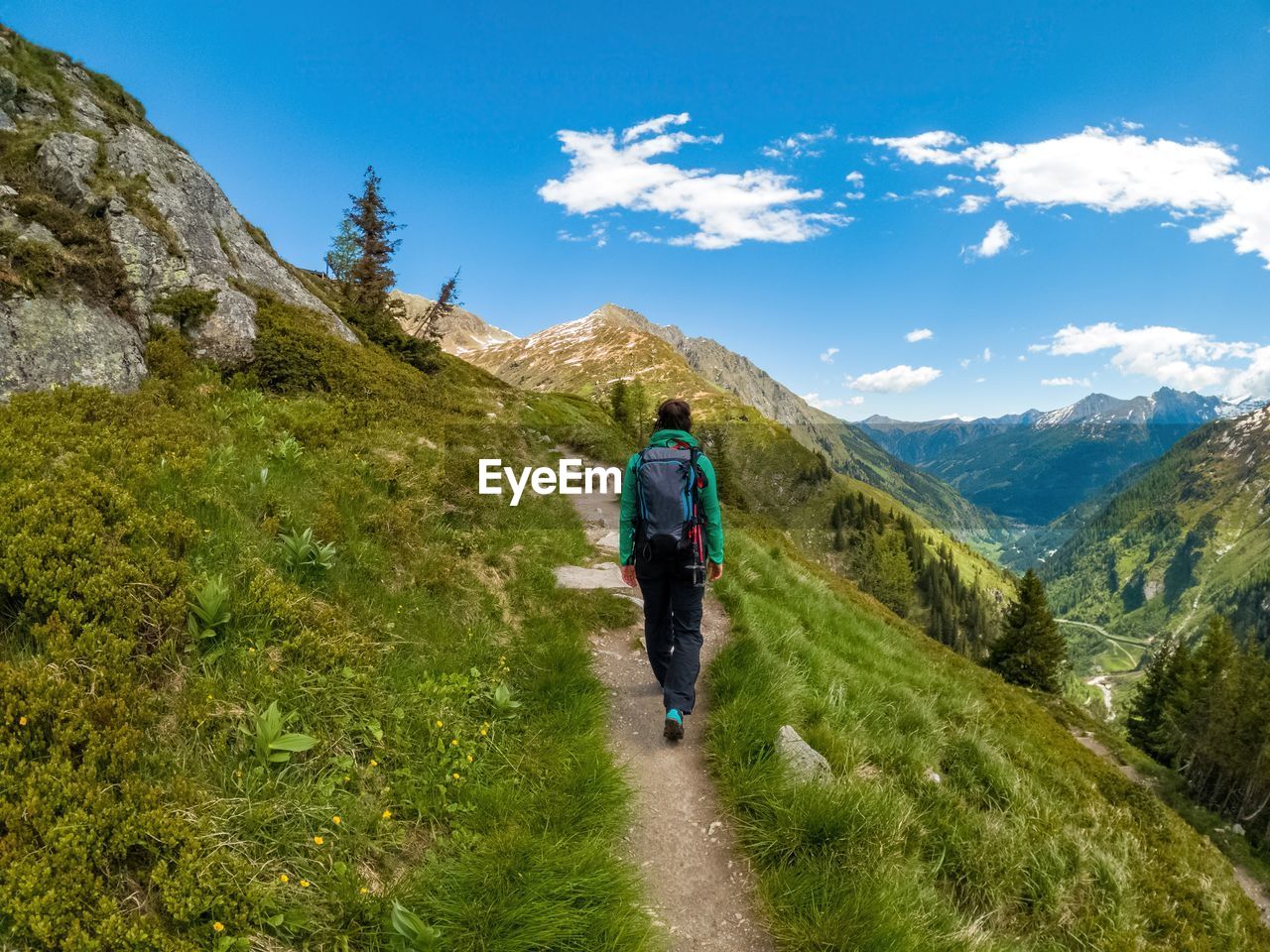 Woman hiking on footpath in the austrian alps near gastein, salzburg, austria