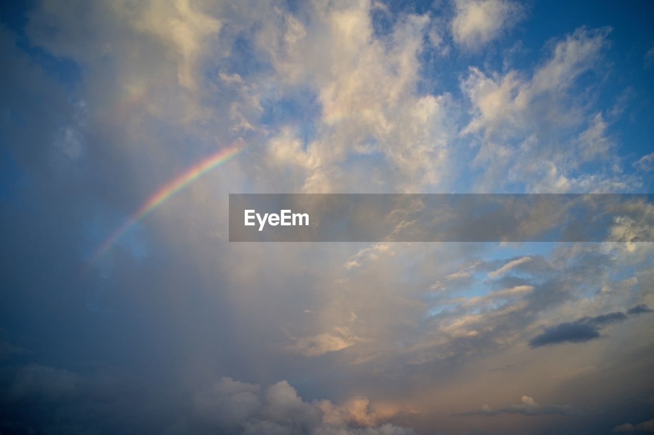 sky, cloud, rainbow, beauty in nature, nature, scenics - nature, sunlight, multi colored, no people, environment, tranquility, dramatic sky, horizon, cloudscape, outdoors, tranquil scene, storm, idyllic, blue, dusk, meteorology, low angle view, sun, day, sunbeam