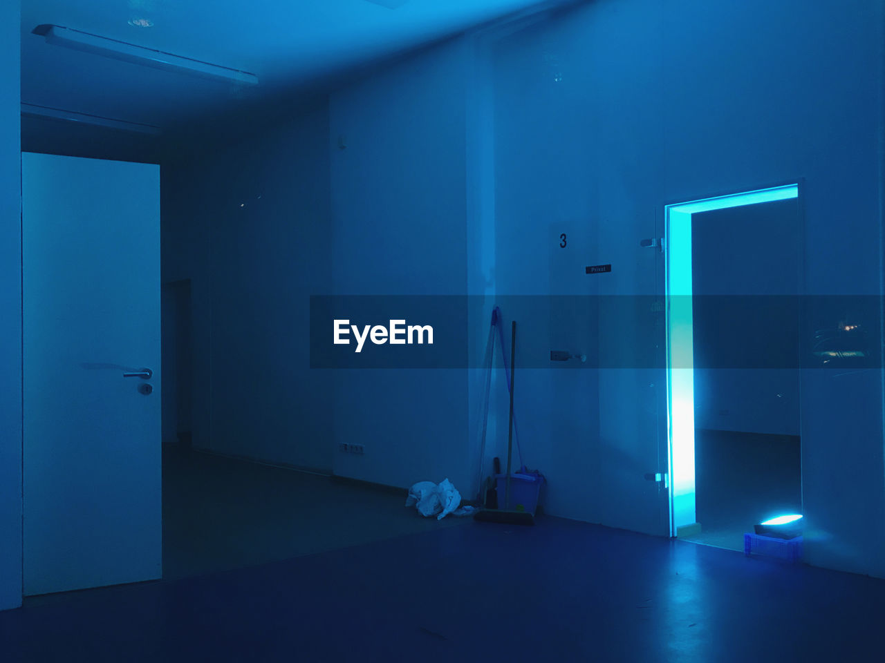 Neon blue illuminated building interior, empty room at night