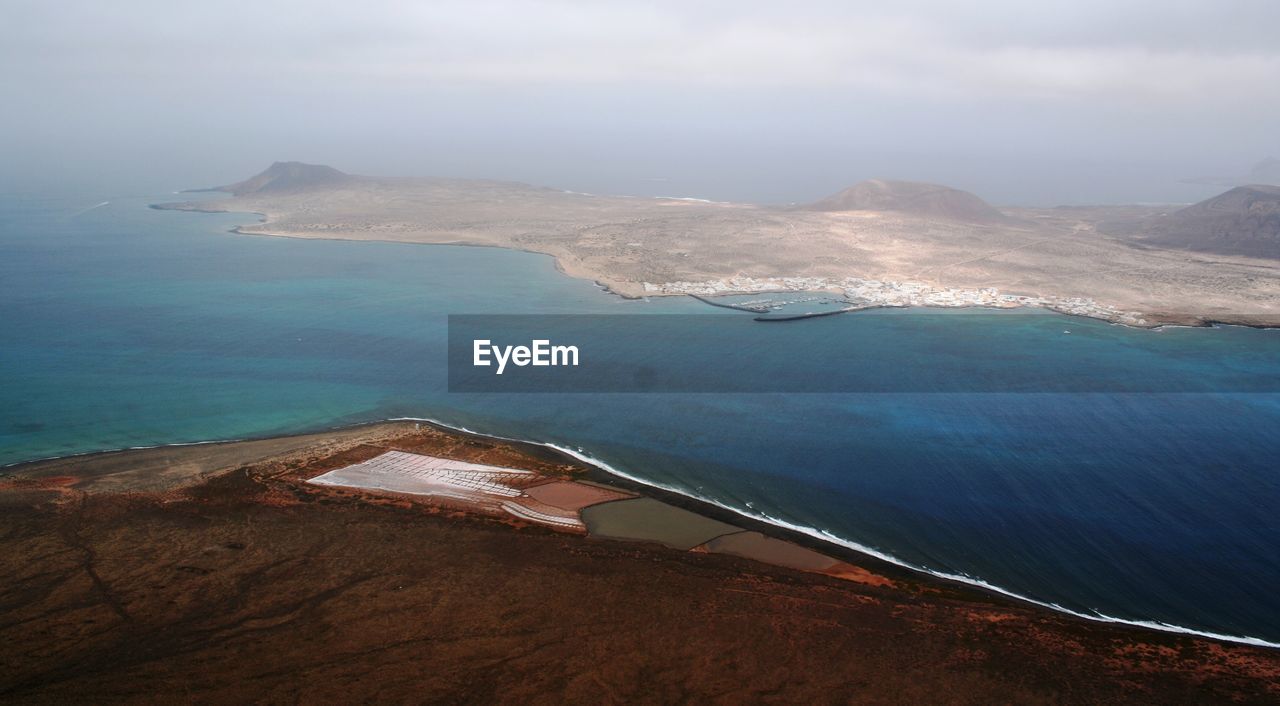 Aerial view of sea and mountains on sunny day at lanzarote