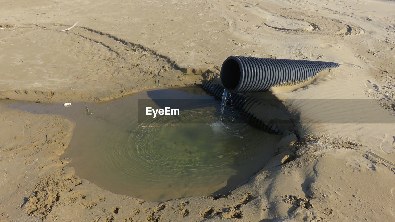 High angle view of water coming out from pipe at beach