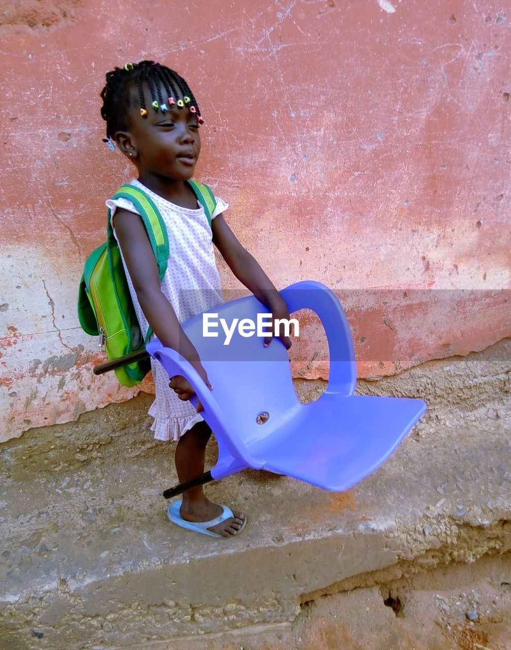 Young beautiful girl from class and carry chair to home.