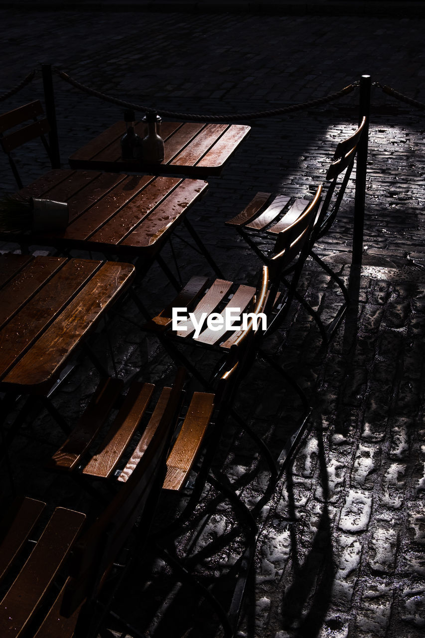 High angle view of empty table and chairs on footpath at night