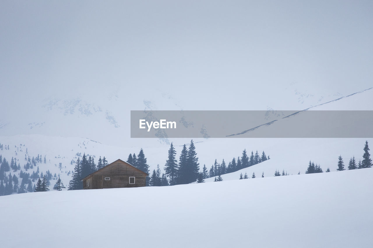 SNOW COVERED LANDSCAPE AGAINST SKY