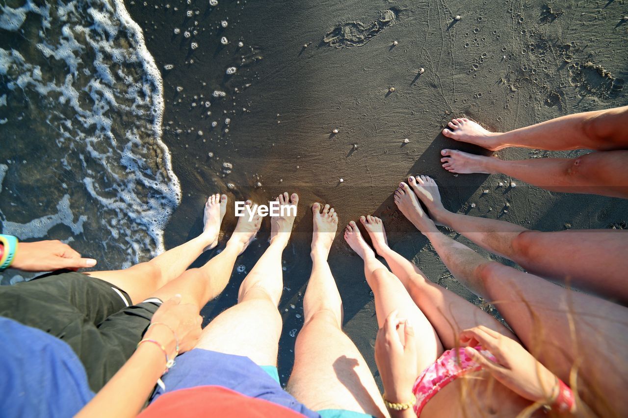 Ten barefoot feet of a family of five on the beach with mum dad and children