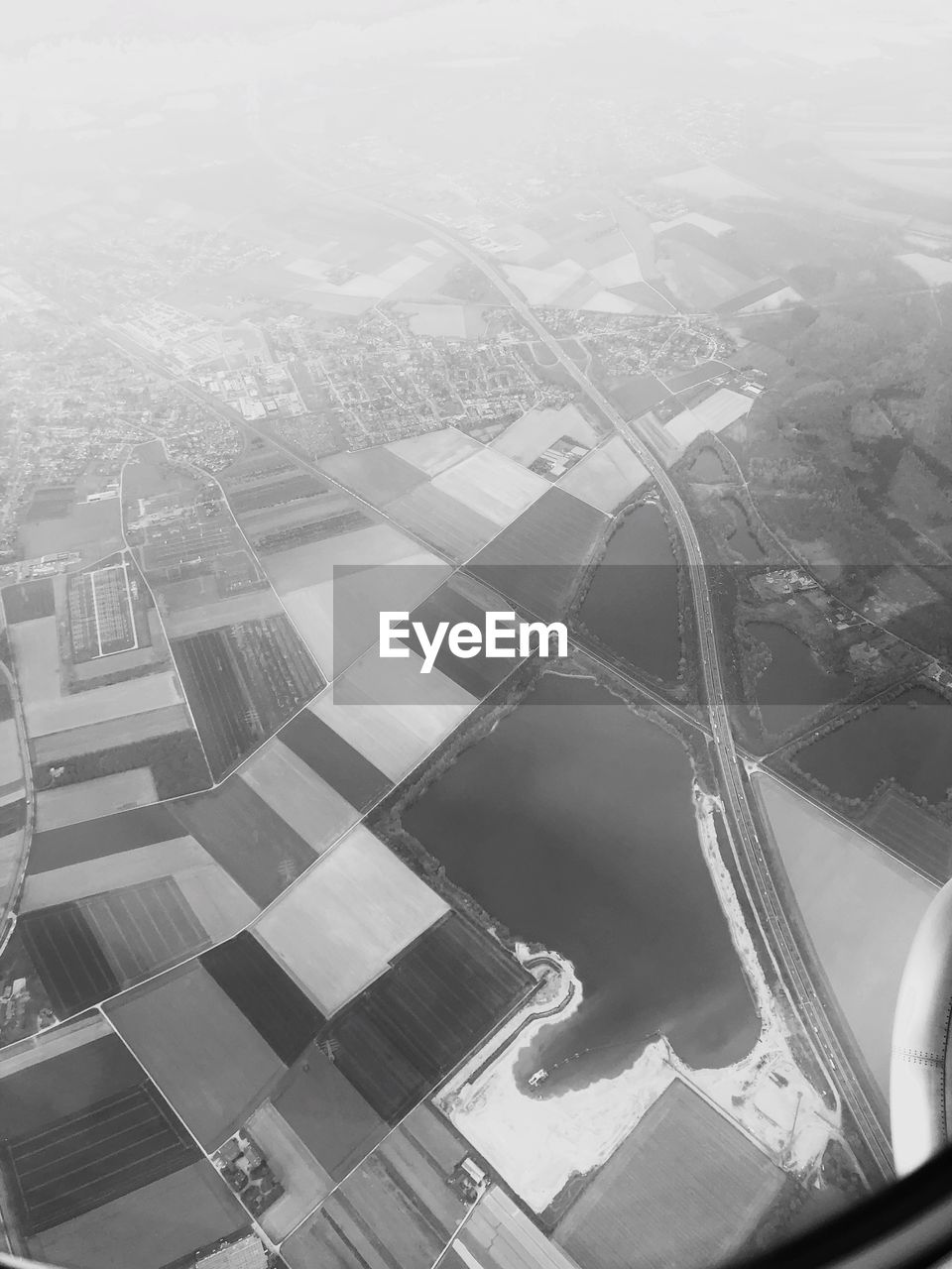 HIGH ANGLE VIEW OF CITY SEEN THROUGH AIRPLANE WINDOW