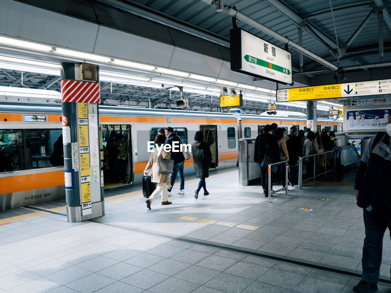 People at railroad station platform in city