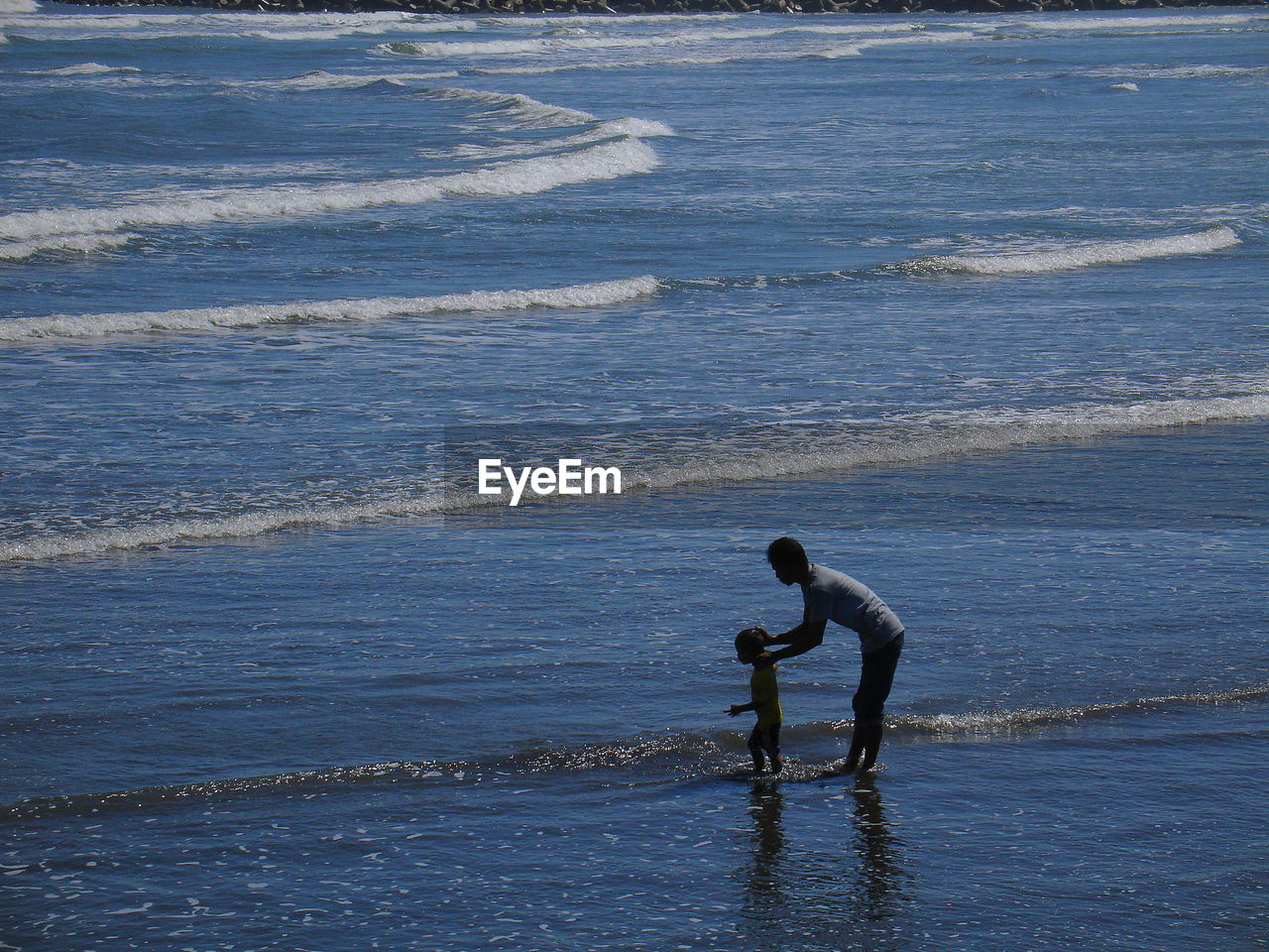 MAN SURFING ON SEA SHORE