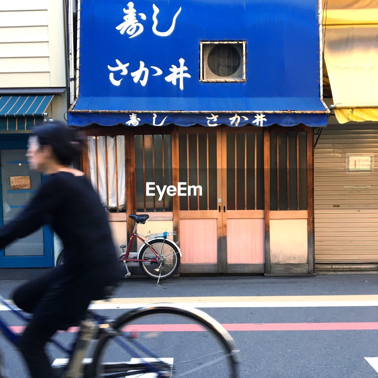 WOMAN STANDING IN FRONT OF BUILDING