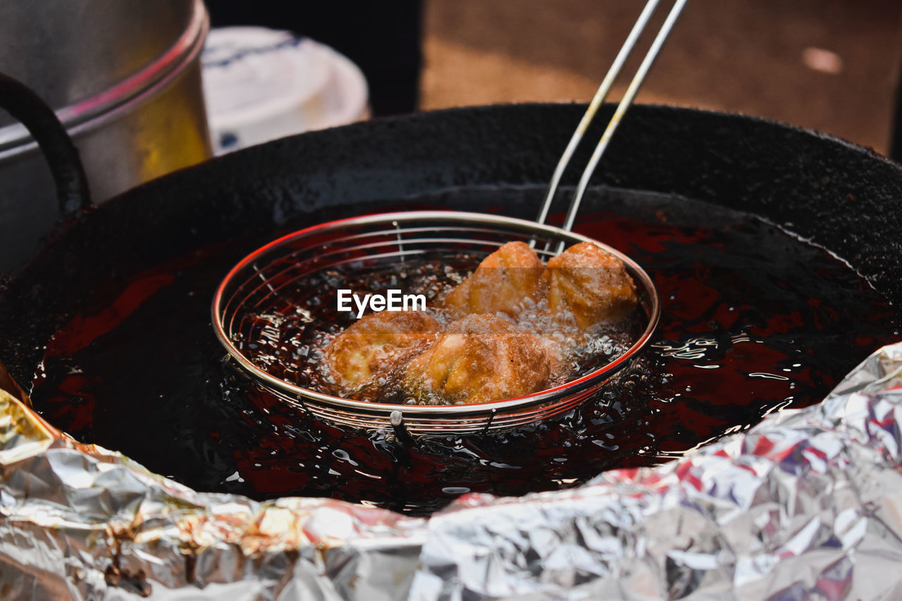 High angle view of frying momos in oil