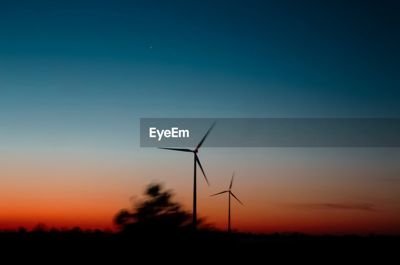SILHOUETTE OF WIND TURBINE AGAINST SKY AT SUNSET