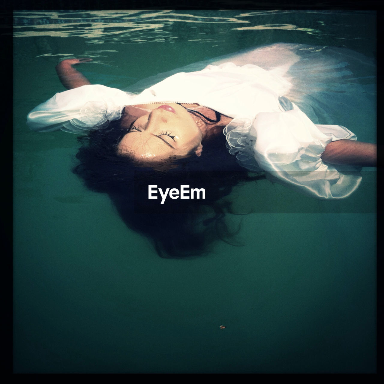 Young woman floating in swimming pool