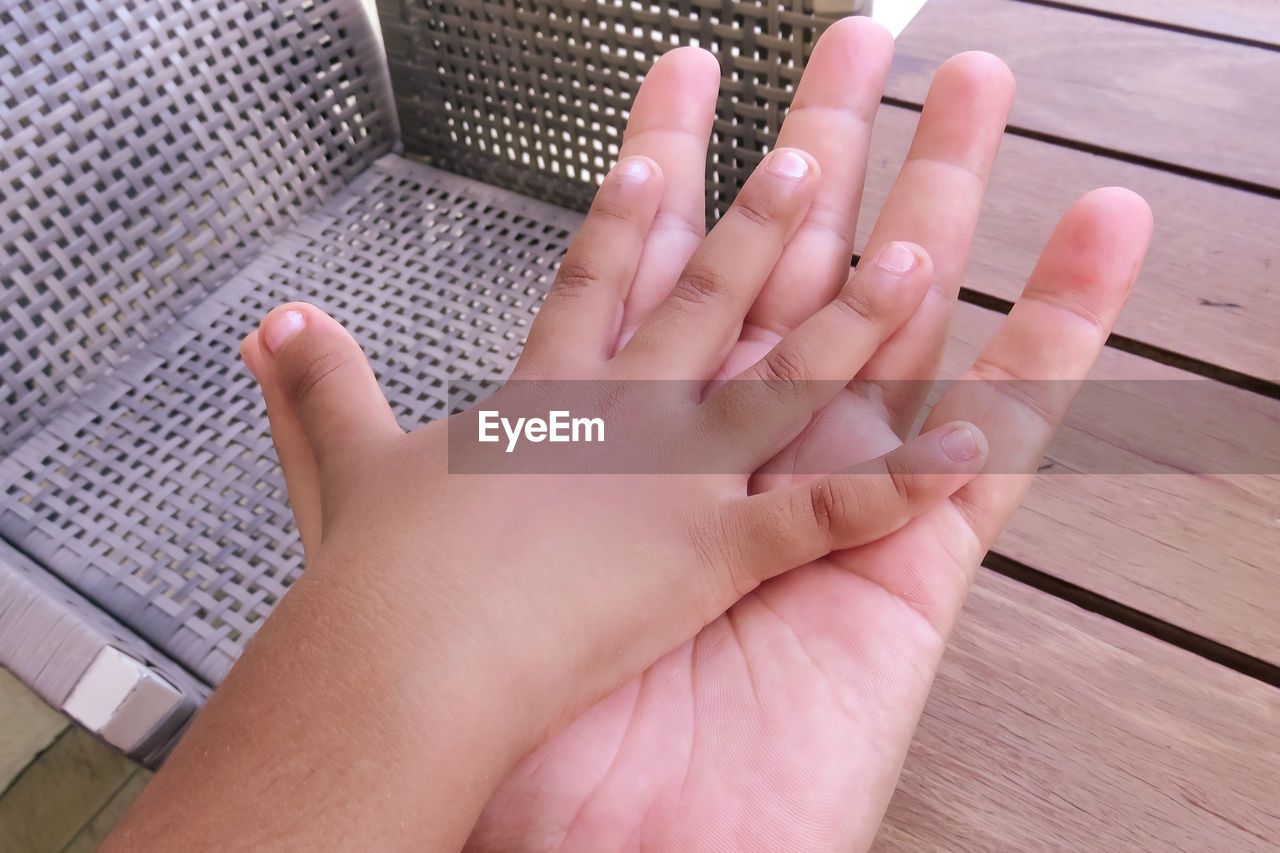 Close-up of child's and adult's hands