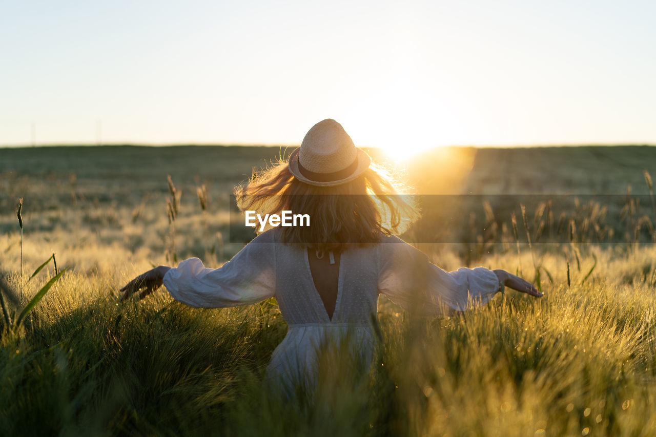 WOMAN ON FIELD AGAINST SKY