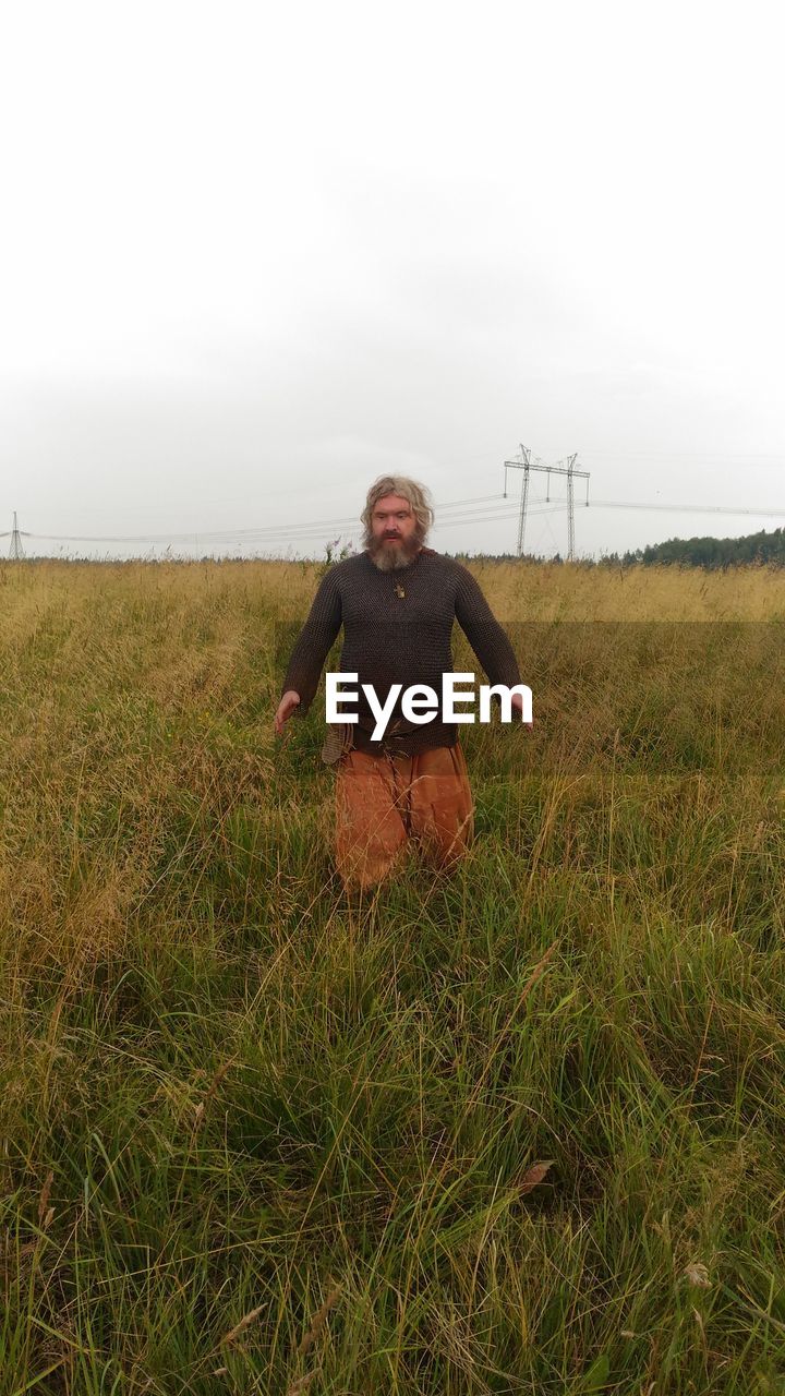 FULL LENGTH PORTRAIT OF MAN STANDING ON FIELD