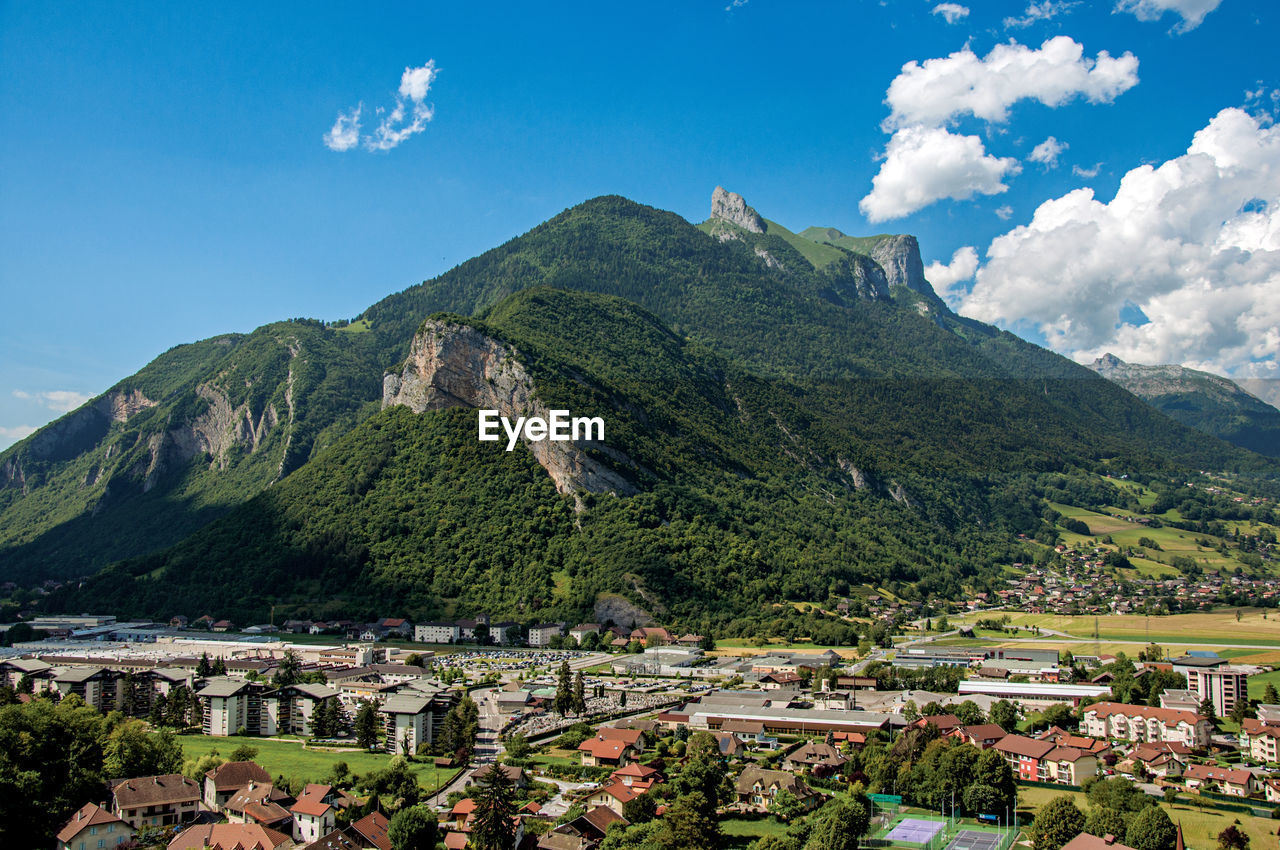 Houses in valley with evergreen mountains viewed from the faverges castle, france.