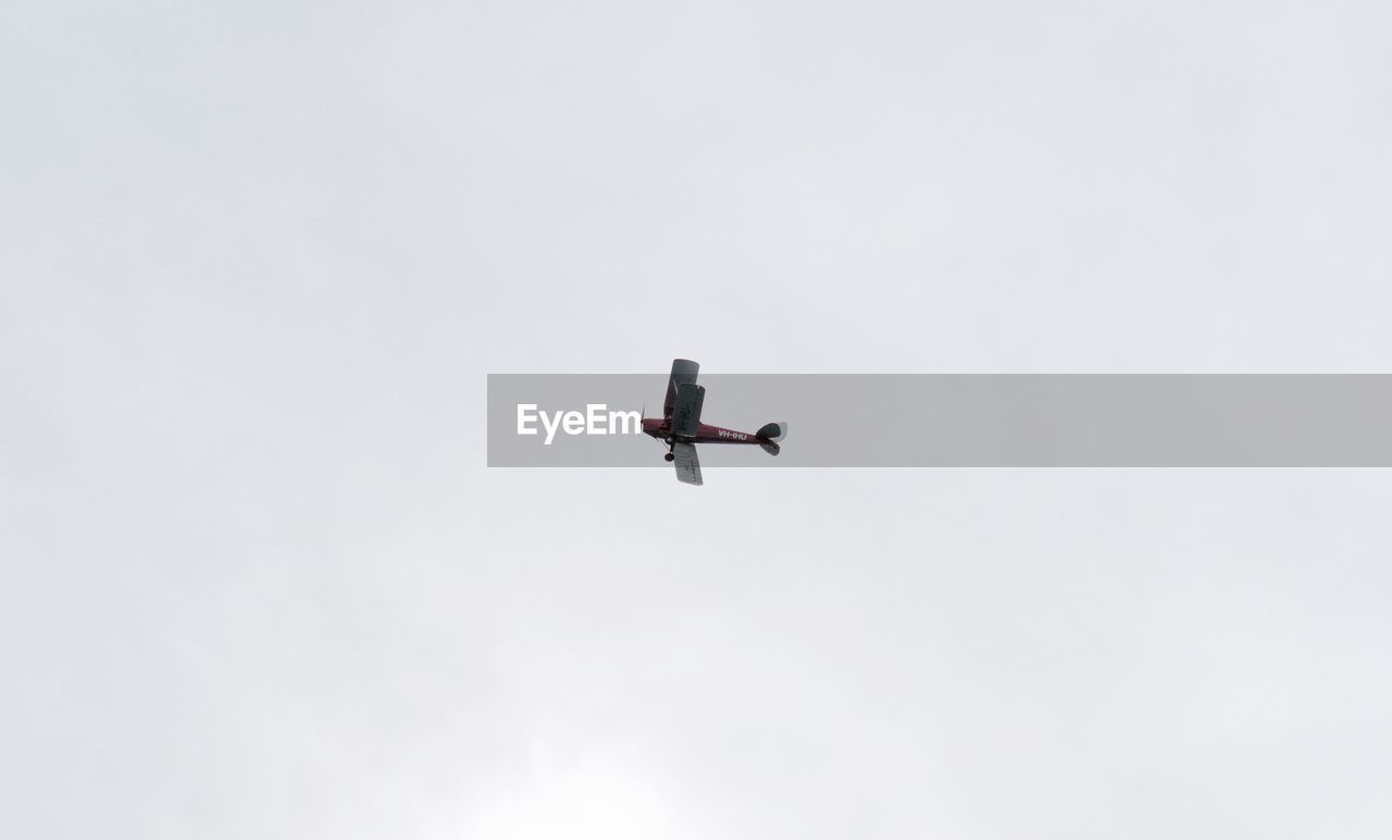 Low angle view of airplane in flight against clear sky