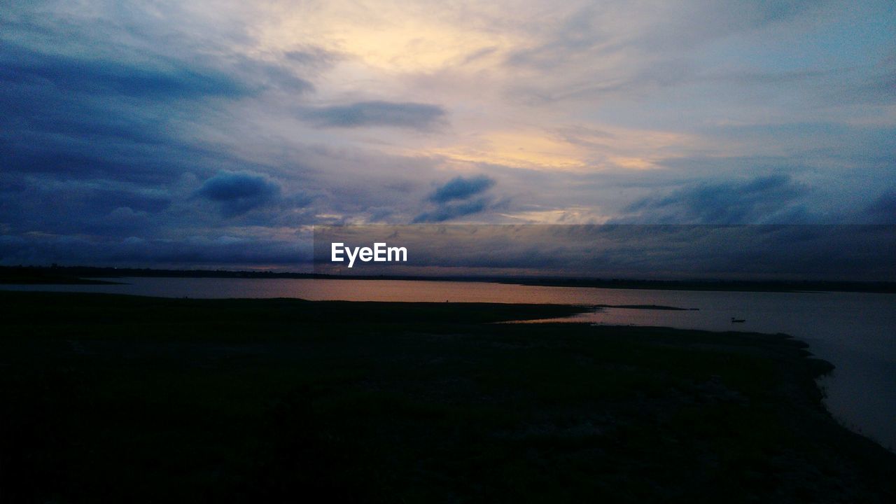 SCENIC VIEW OF BEACH AGAINST SKY DURING SUNSET