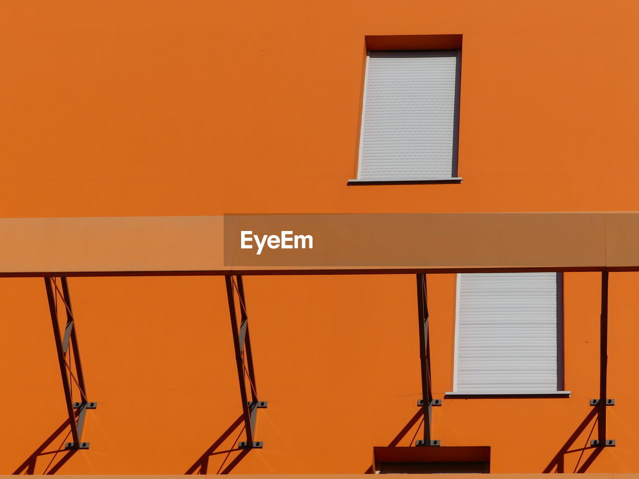 LOW ANGLE VIEW OF ORANGE BUILDING AGAINST CLEAR SKY