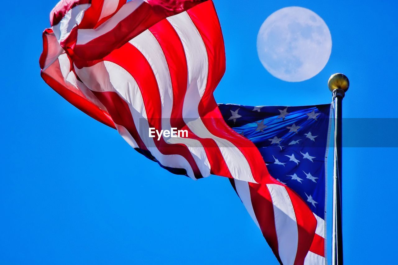 Low angle view of flag against blue sky