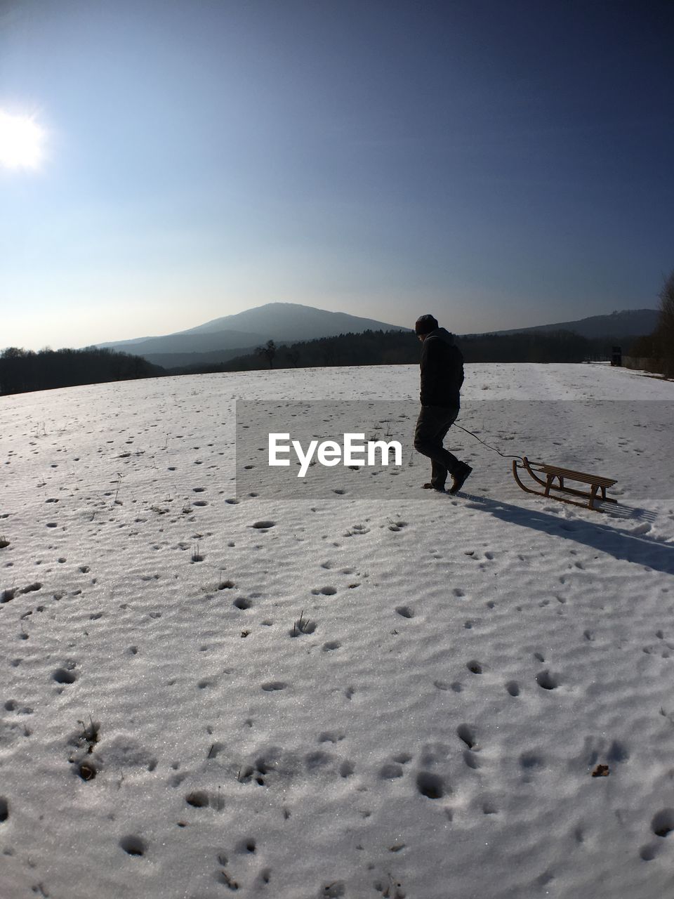 MAN ON SNOW COVERED LANDSCAPE
