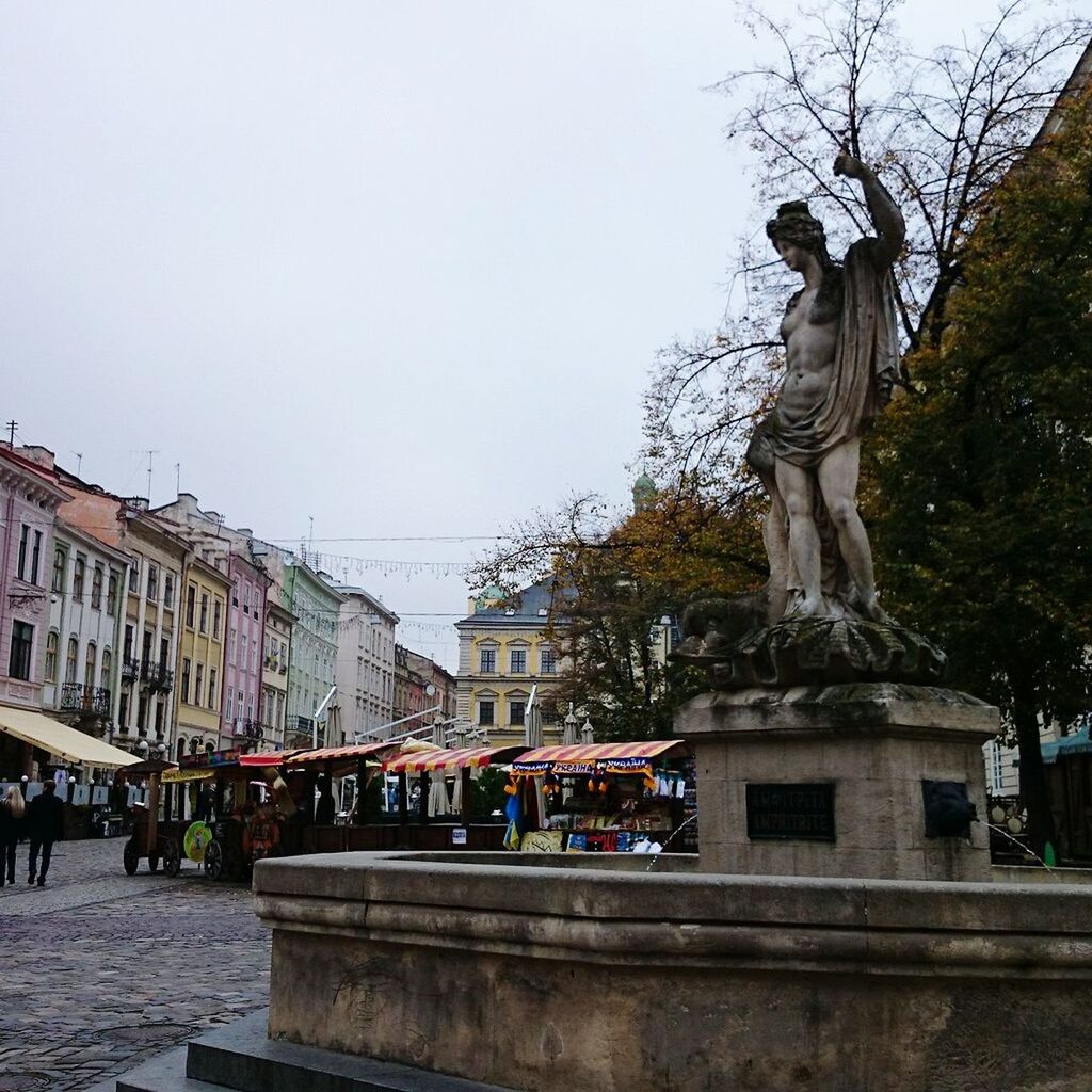 STATUE OF WOMAN IN CITY