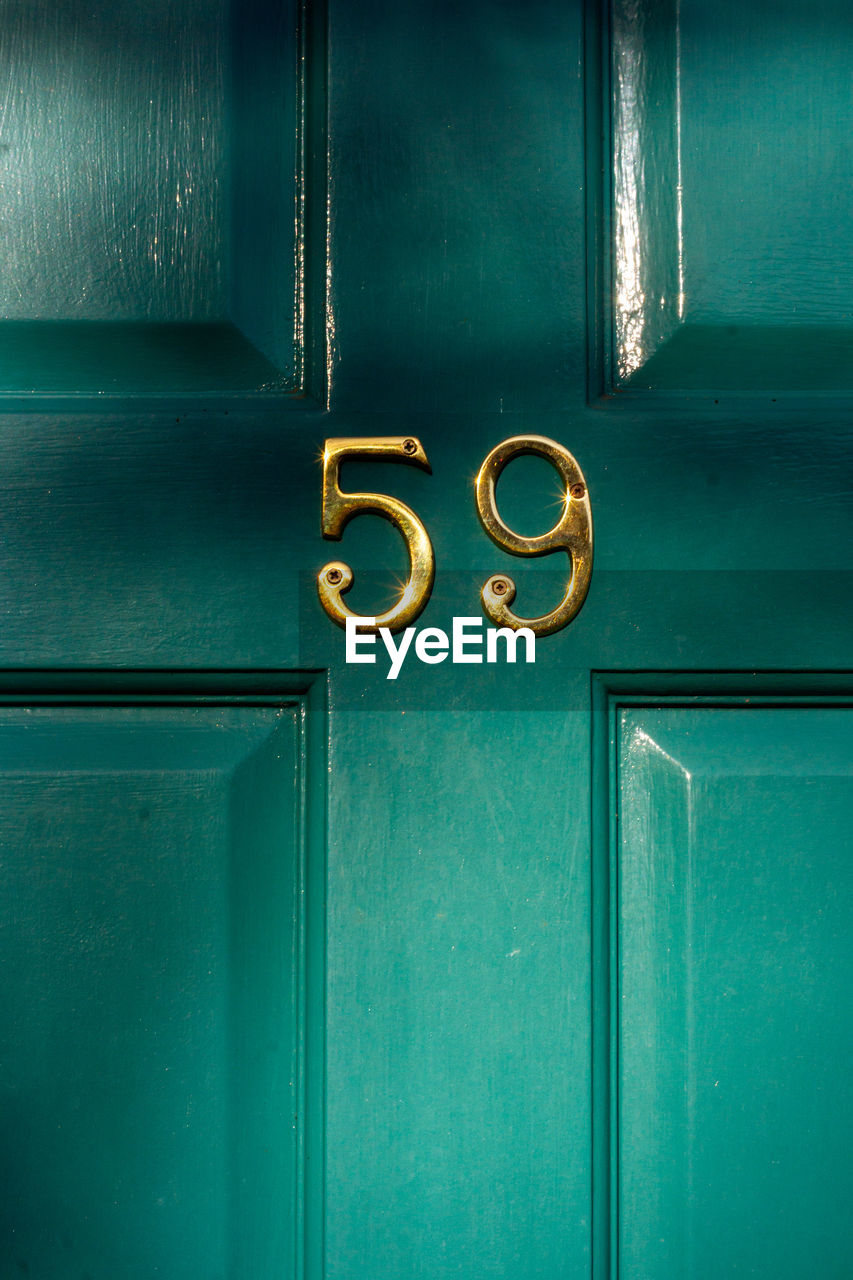 House number 59 on a turquoise wooden front door in london