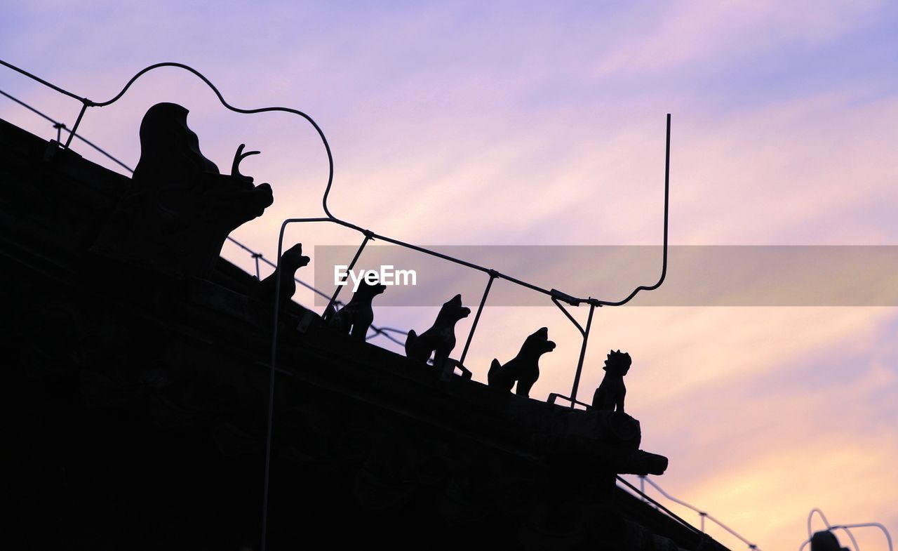 LOW ANGLE VIEW OF SILHOUETTE BIRDS PERCHING ON POWER LINES