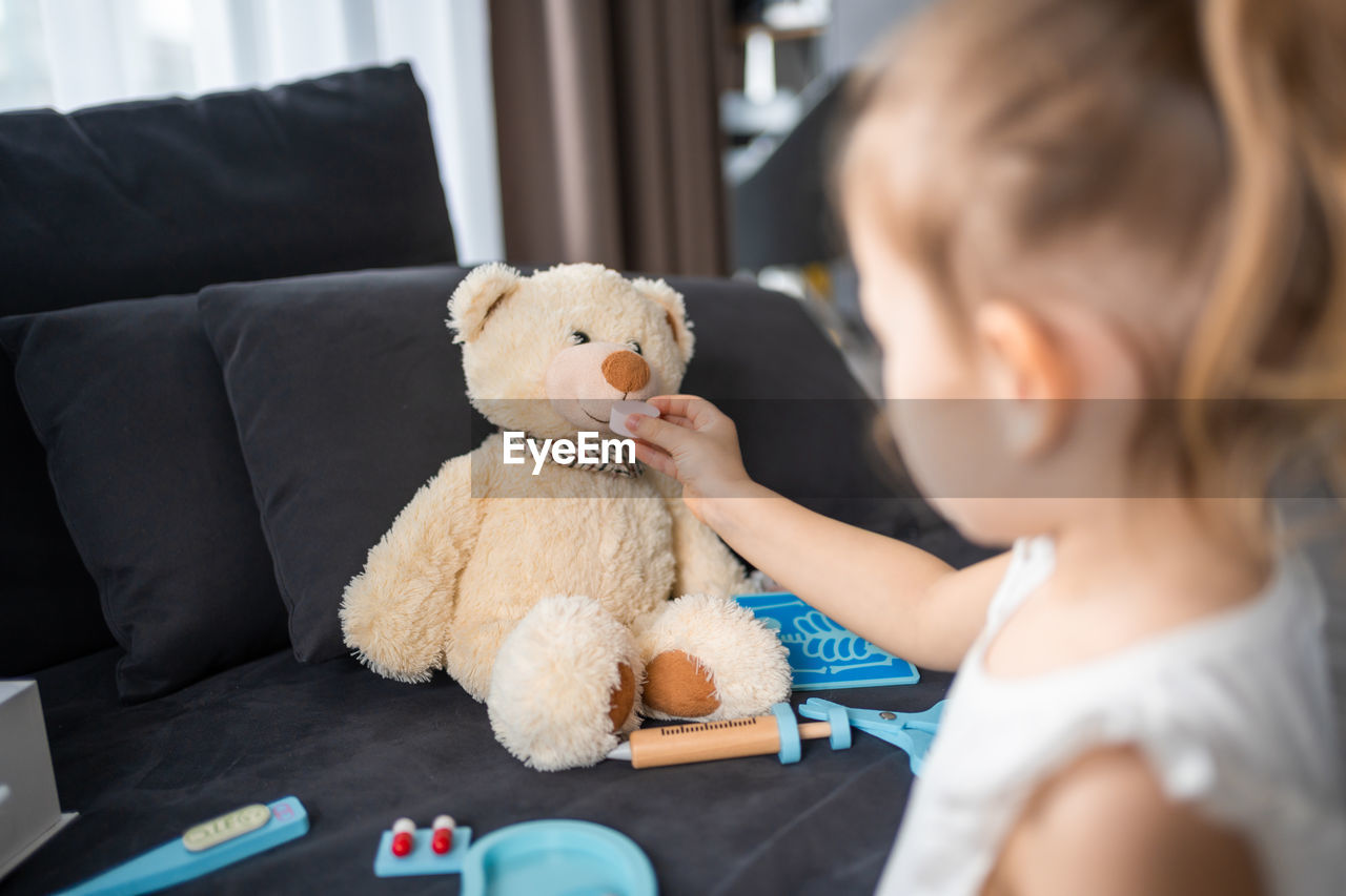 young woman with teddy bear at home