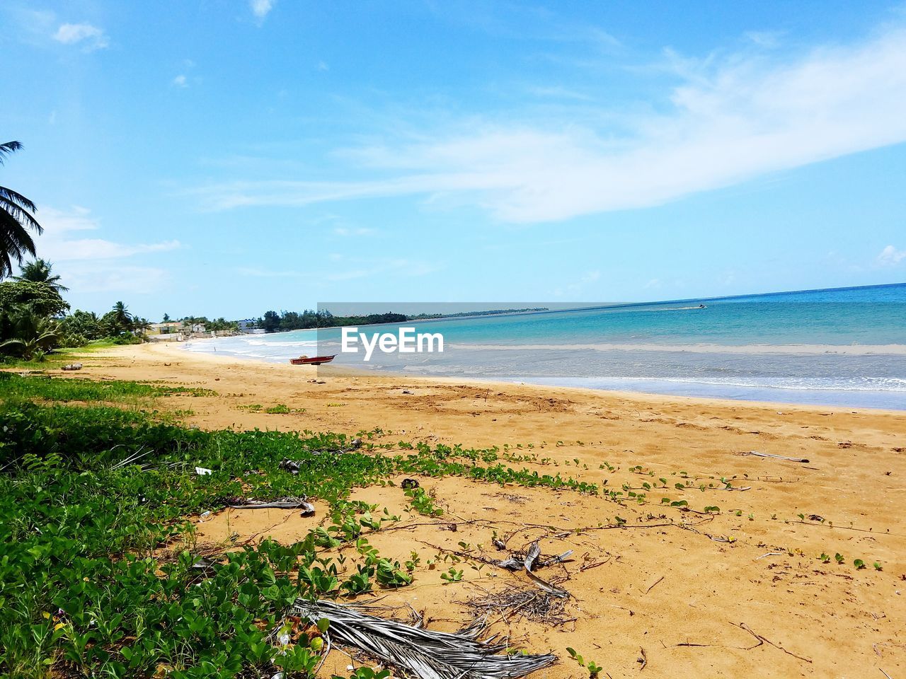 Scenic view of beach against cloudy sky