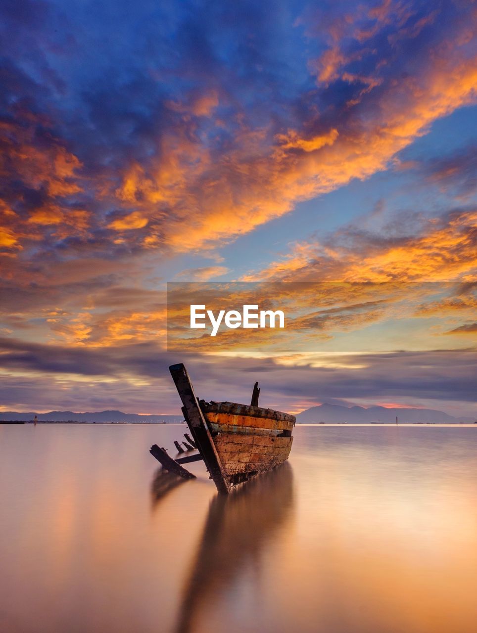 Ship in sea against sky during sunset