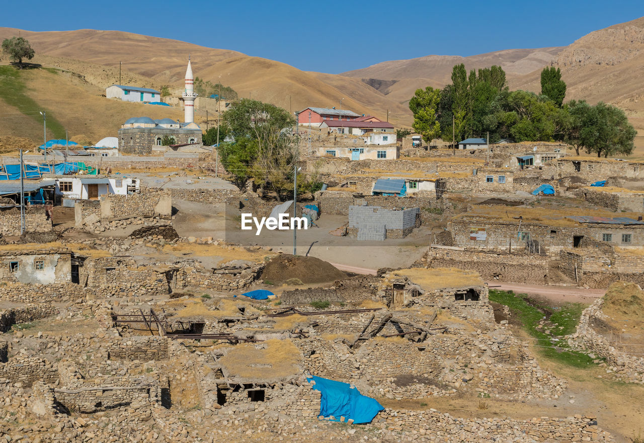 HIGH ANGLE VIEW OF BUILDINGS AGAINST MOUNTAINS