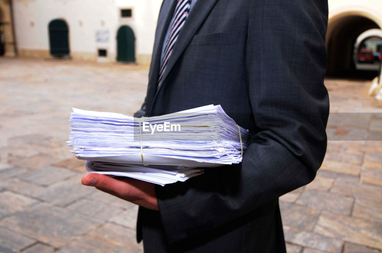 Man in suit with files and paperwork in the administration