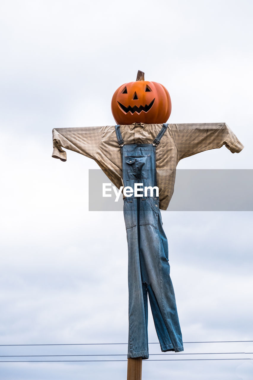 Low angle view of scarecrow against sky